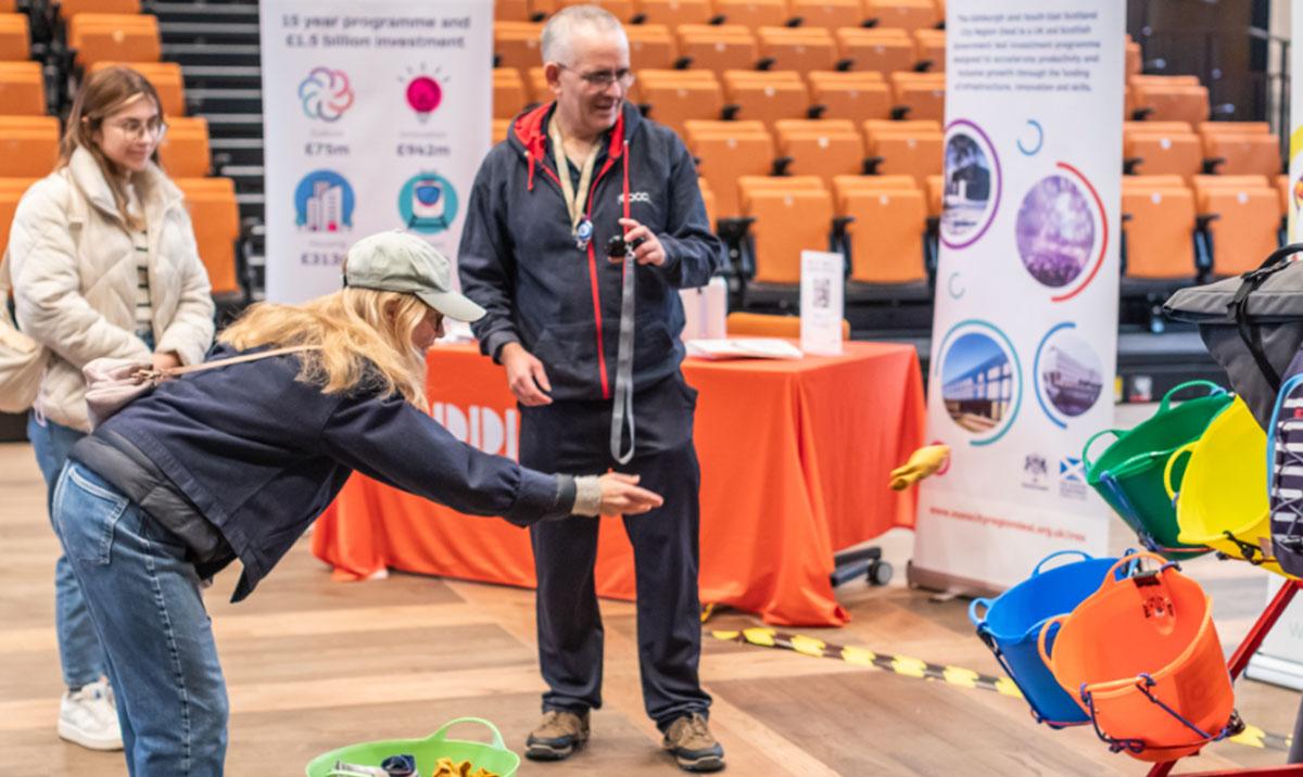 Photo shows people trying tasks at a science festival. Image by Chris Scott.