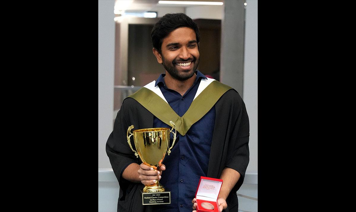 Jaffery holding trophy cup and boxed medal