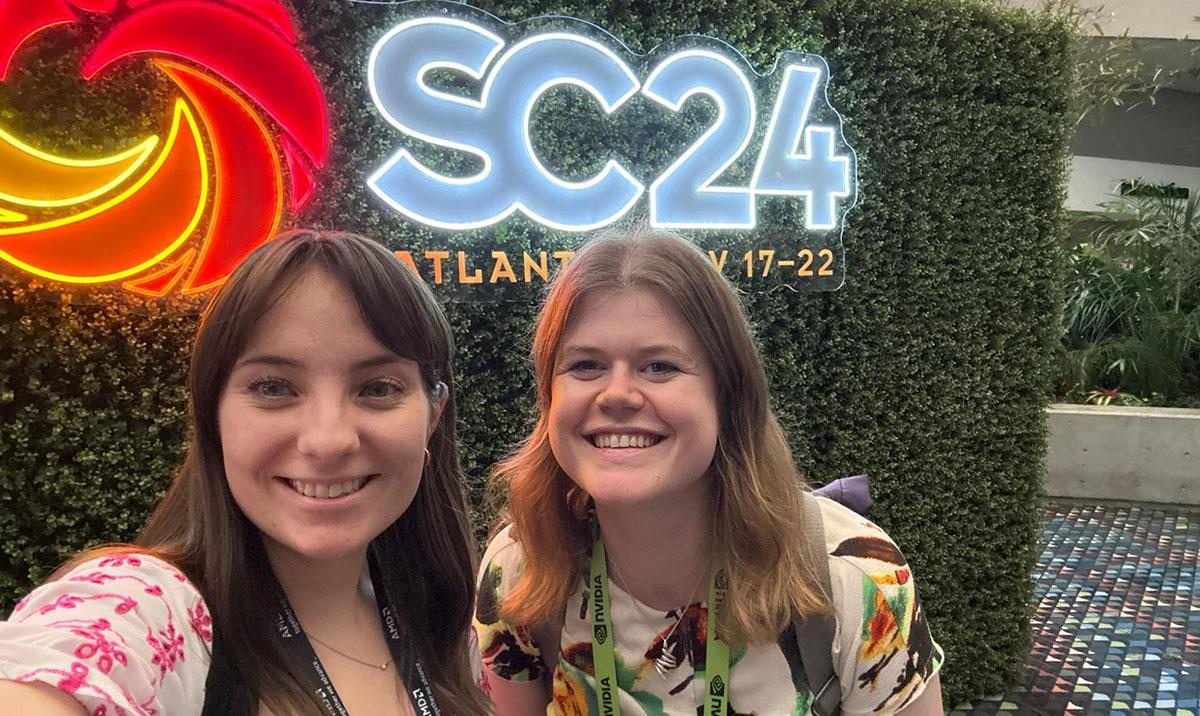 Photo shows Laura Moran and Eleanor Broadway beside the SC24 logo