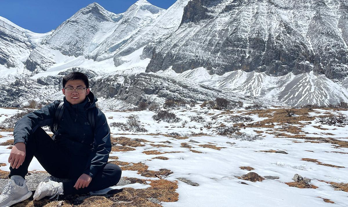 Xingran Ruan photographed with snowy mountain in background.